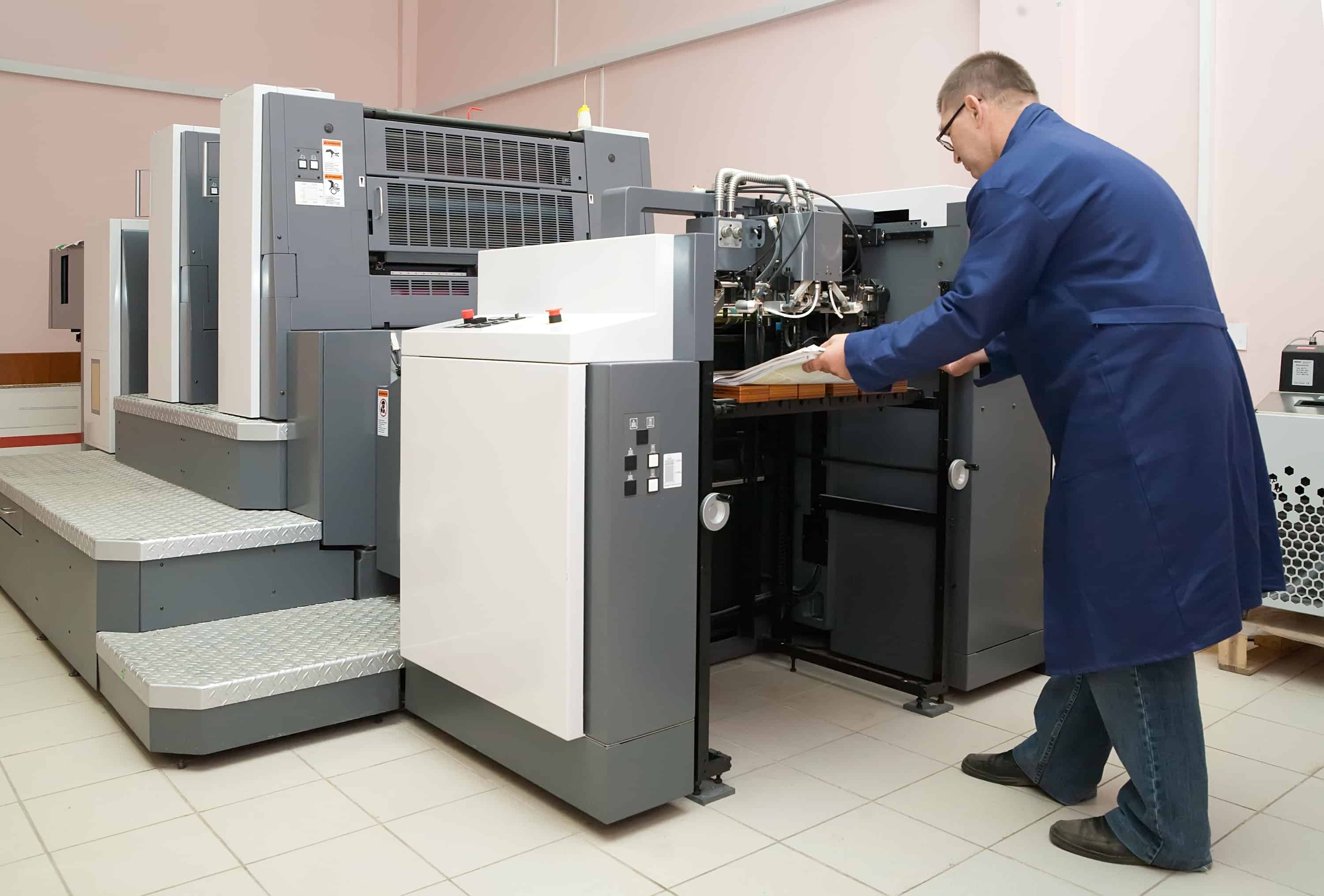 Homem segurando papel saindo de máquina de impressão digital